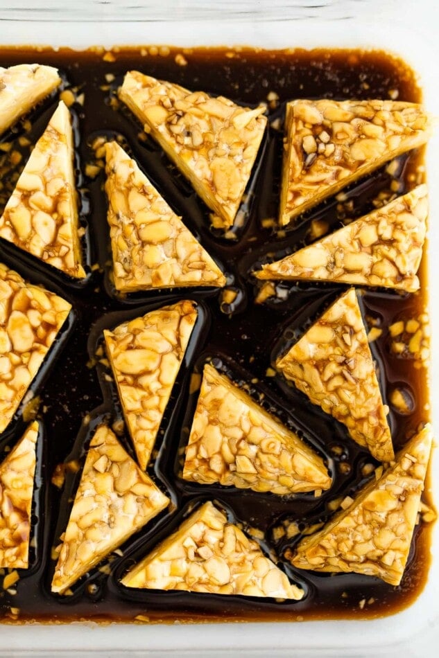 A close up of tempeh triangles marinating in a maple balsamic glaze.