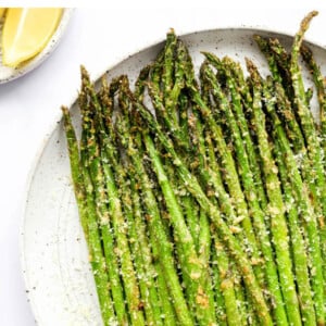 Plate of air fryer asparagus topped with parmesan.