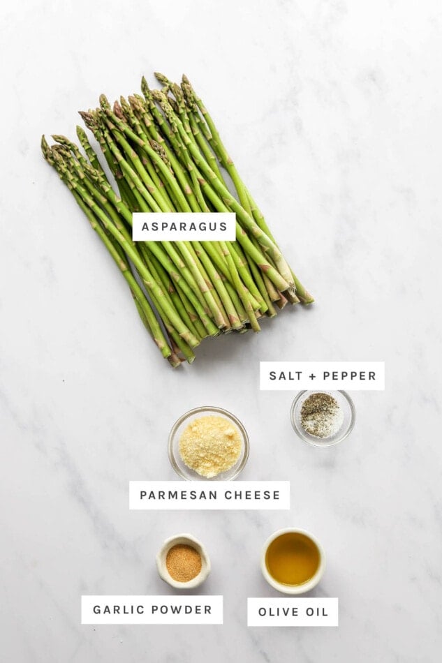 Ingredients measured out to make air fryer asparagus: asparagus, salt, pepper, parmesan cheese, garlic powder and olive oil.