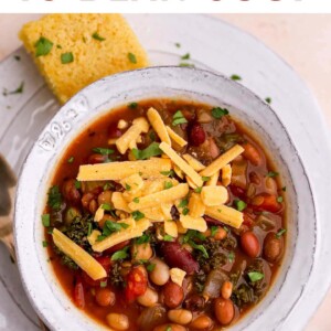 Bowl of bean soup topped with shredded cheddar.