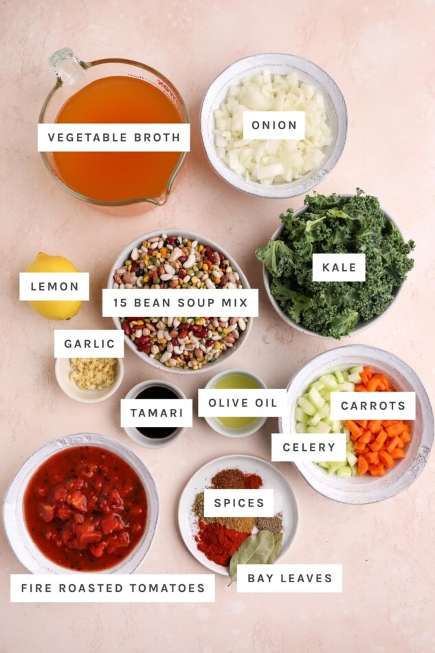 Ingredients measured out to make 15 bean soup: vegetable broth, onion, kale, 15 bean soup mix, lemon, garlic, tamari, olive oil, celery, carrots, spices, bay leaves and fire roasted tomatoes.