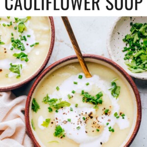 A bowl of cauliflower soup topped with fresh herbs.