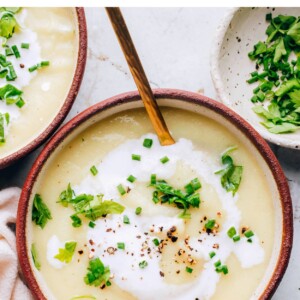 A bowl of cauliflower soup topped with fresh herbs.