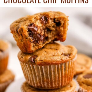 Stack of three chocolate chip muffins. Top muffin has a bite out of it.