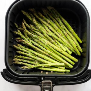Asparagus spears in an air fryer basket.