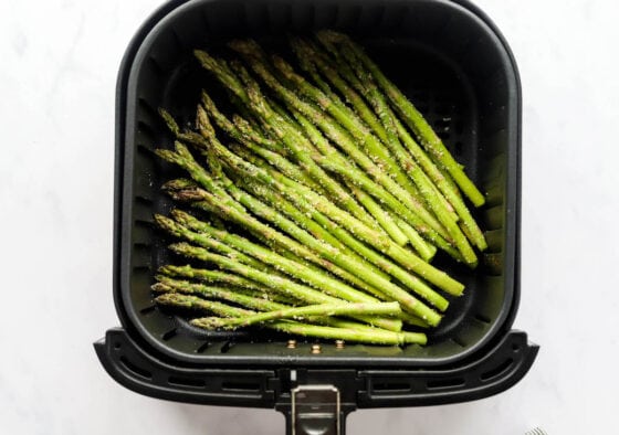 Asparagus spears in an air fryer basket.