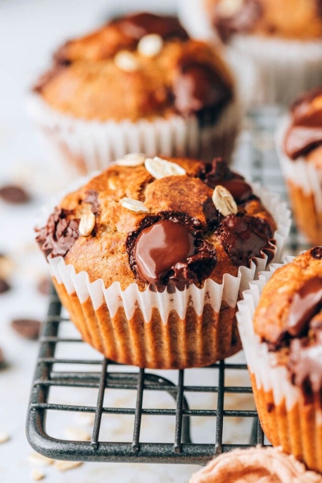 A closeup of an oatmeal banana muffin on a wire cooling rack.