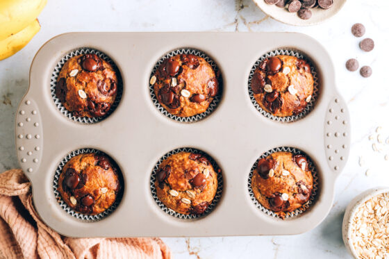 Six baked oatmeal banana muffins in a muffin tin.