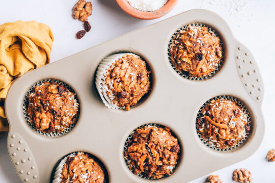 Six baked morning glory muffins in a muffin tin.