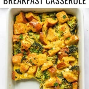 A baking dish containing healthy breakfast casserole. A portion is missing from the baking dish and a spoon rests in its place.