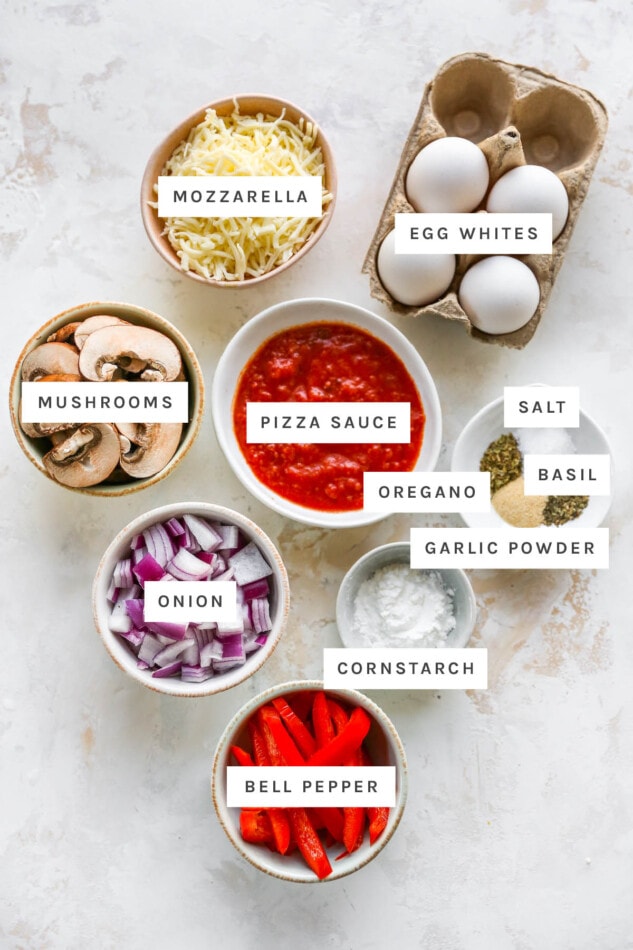 Ingredients measured out to make cloud bread pizza: mozzarella, egg whites, pizza sauce, mushrooms, salt, basil, oregano, garlic powder, cornstarch, onion and bell pepper.