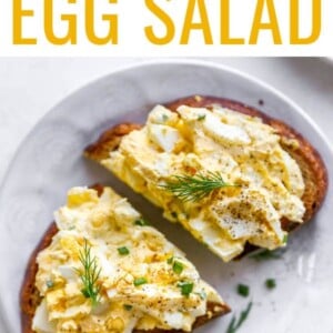 A plate with a slice of bread topped with healthy egg salad. The slice has been cut in half.