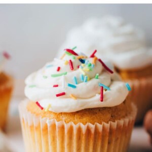 A health vanilla cupcake topped with icing and sprinkles.