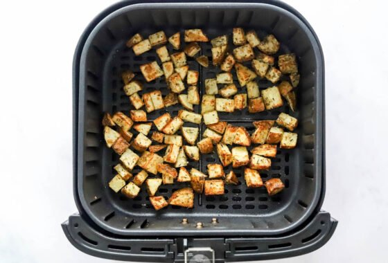 Air fried breakfast potatoes in an air fryer basket.