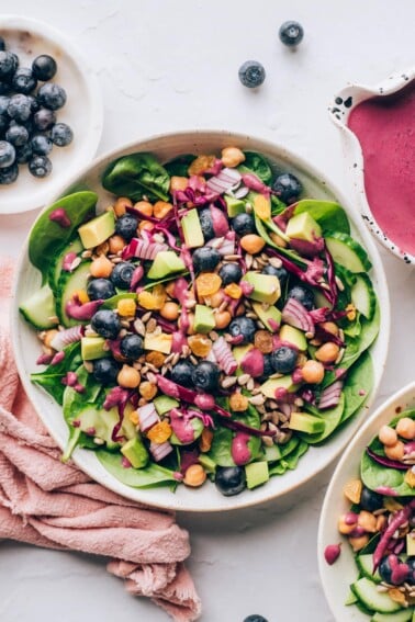 An overhead photo looking down at a bowl of spinach blueberry salad.