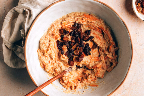 Wet and dry ingredients combined in a bowl. Raisins have been added to the bowl.