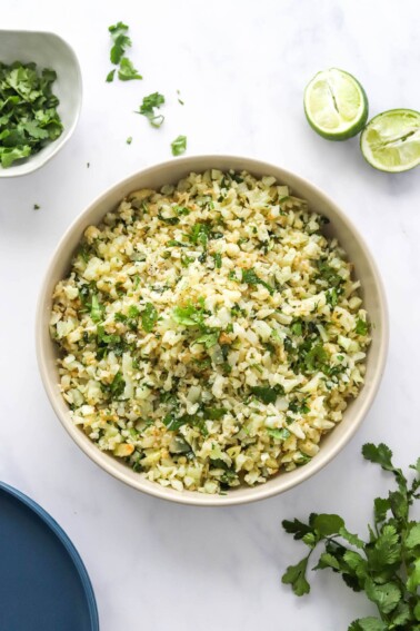 Looking down at a serving bowl containing cilantro lime cauliflower rice.