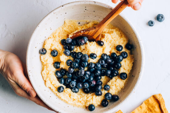 Folding in fresh blueberries to the muffin batter.