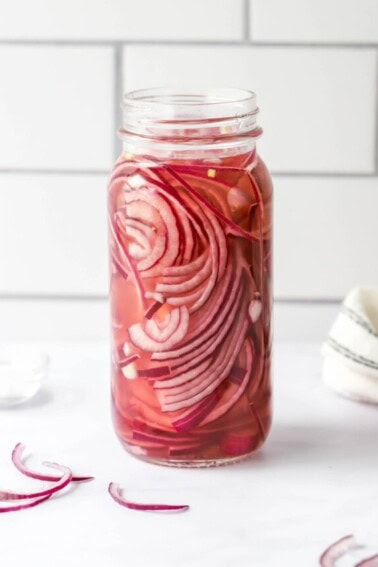A jar containing quick pickled onions.