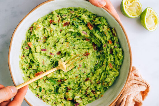 Mashed ingredients in a bowl to make guacamole.