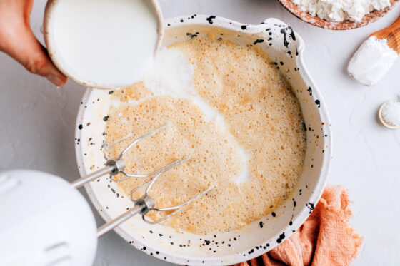 Adding the almond milk and apple cider vinegar mixture to the sugar and butter mixture.