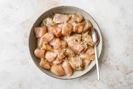 Chunks of chicken in a bowl, tossed with Lemon Garlic sauce.