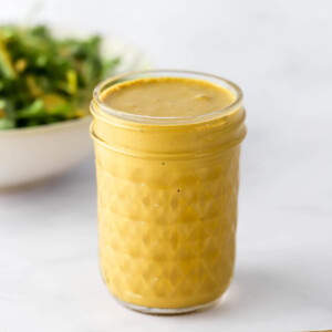 A mason jar filled with creamy nutritional yeast dressing.