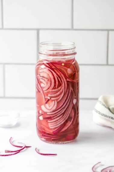 A jar containing quick pickled onions.