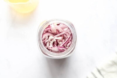 A jar containing sliced red onions.