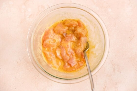 Chicken marinating in egg, arrowroot powder, salt and pepper.