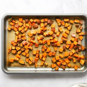 Freshly roasted sweet potato croutons on a baking sheet lined with parchment paper.