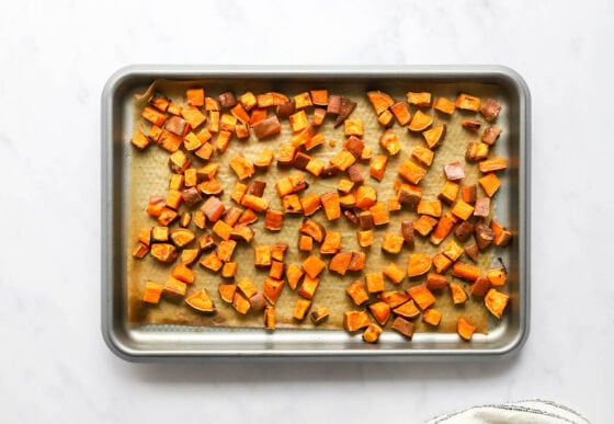 Freshly roasted sweet potato croutons on a baking sheet lined with parchment paper.