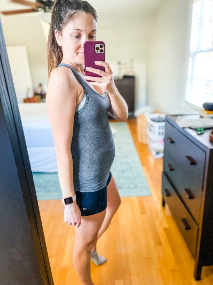 Woman in workout clothes 18 week pregnant.