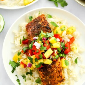 A filet of blackened salmon served over a bed of rice topped with pineapple salsa.