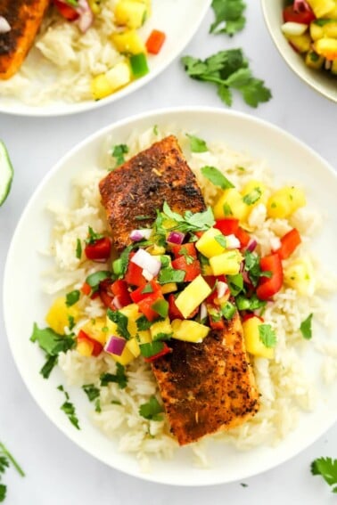 A filet of blackened salmon served over a bed of rice topped with pineapple salsa.