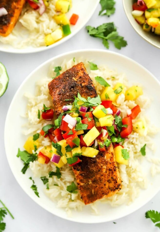 A filet of blackened salmon served over a bed of rice topped with pineapple salsa.