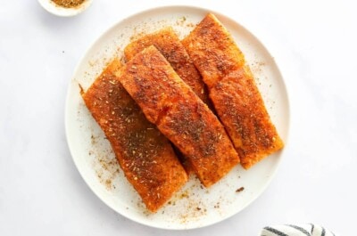 Four salmon filets covered in seasoning.