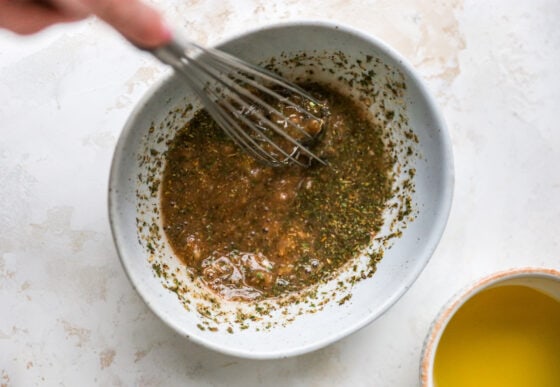 Mixing together spices, red wine vinegar and mustard.