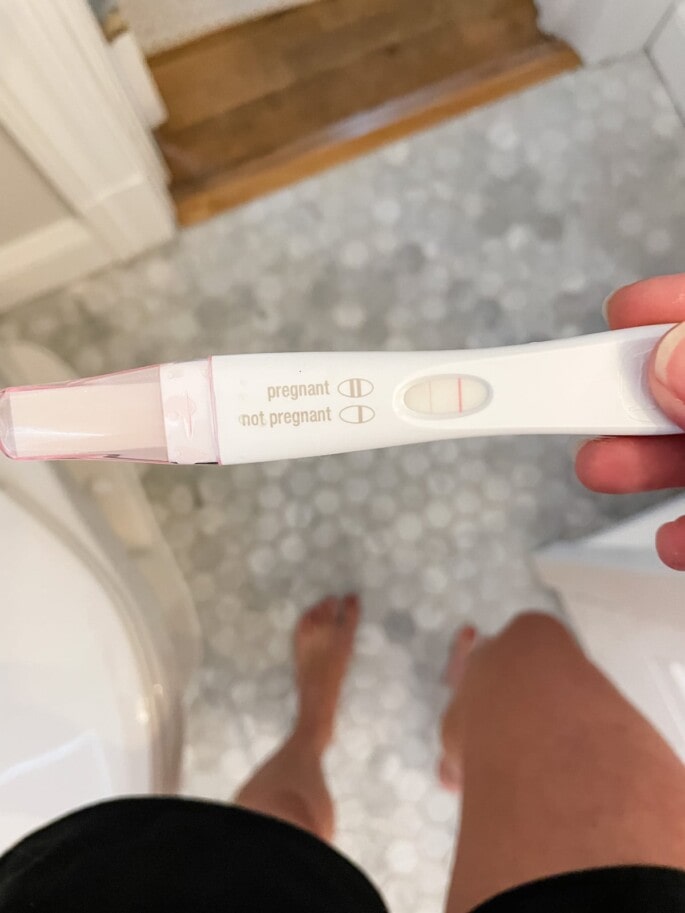 Woman holding positive pregnancy test.