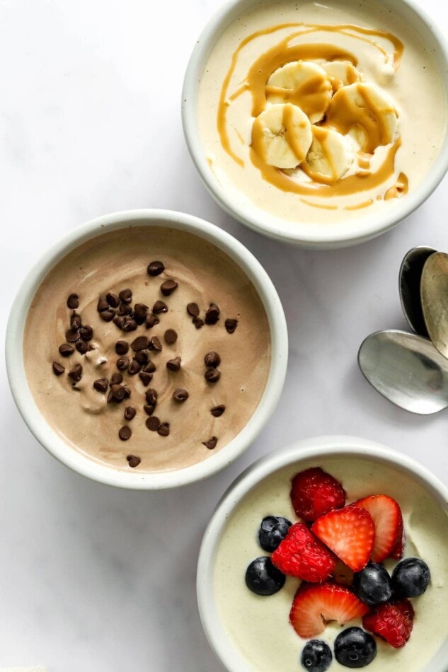 Three small dishes containing protein pudding 3 ways: peanut butter, chocolate, and vanilla.