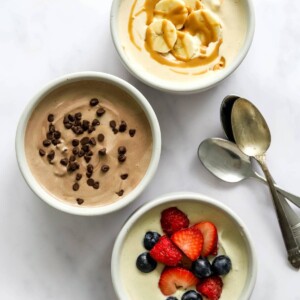 Three small dishes containing protein pudding 3 ways: peanut butter, chocolate, and vanilla.