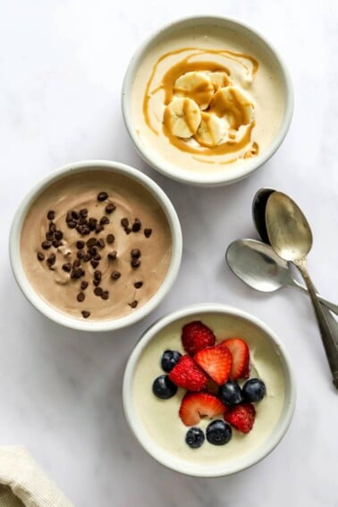 Three small dishes containing protein pudding 3 ways: peanut butter, chocolate, and vanilla.