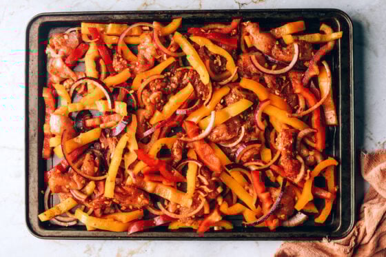 Chicken and vegetables spread on a sheet pan.