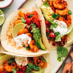 Three fajitas on a serving platter.