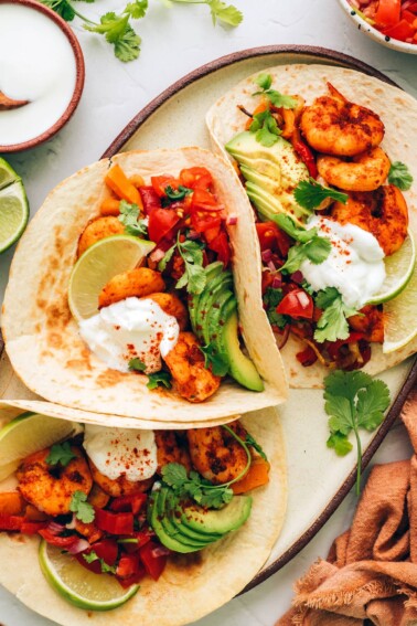 Three fajitas on a serving platter.