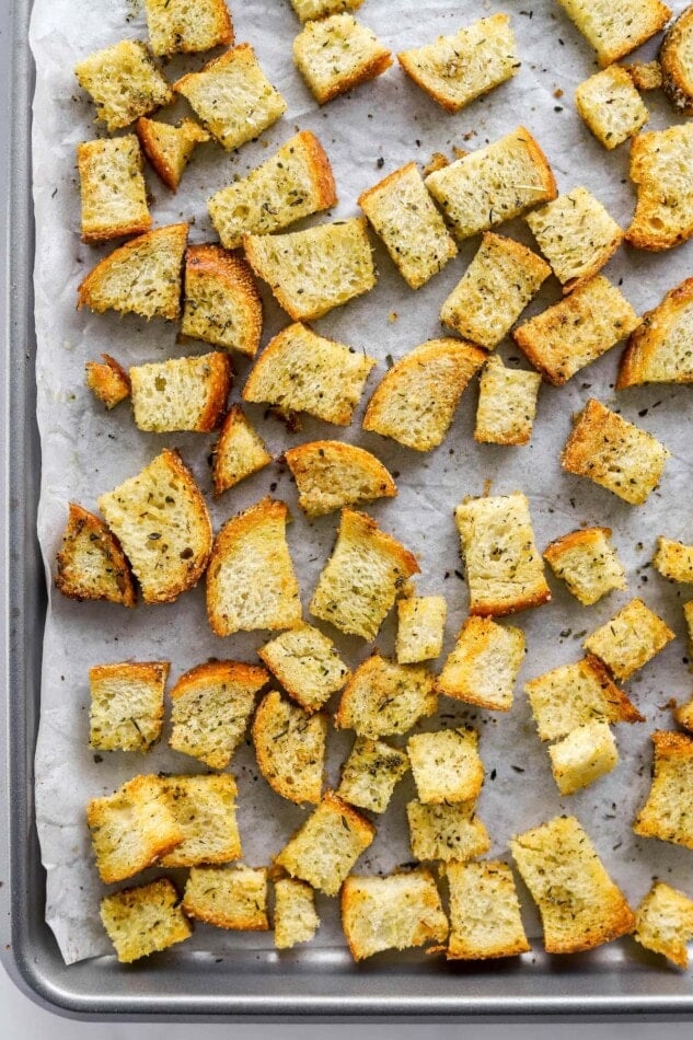 Sourdough croutons on a baking sheet lined with parchment paper.