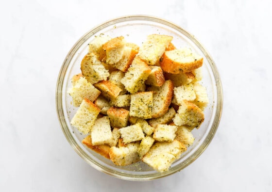 Cubes of sourdough in a bowl tossed with spices.