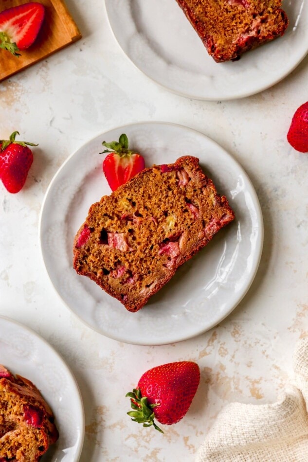 A loaf of strawberry banana bread on a plate.