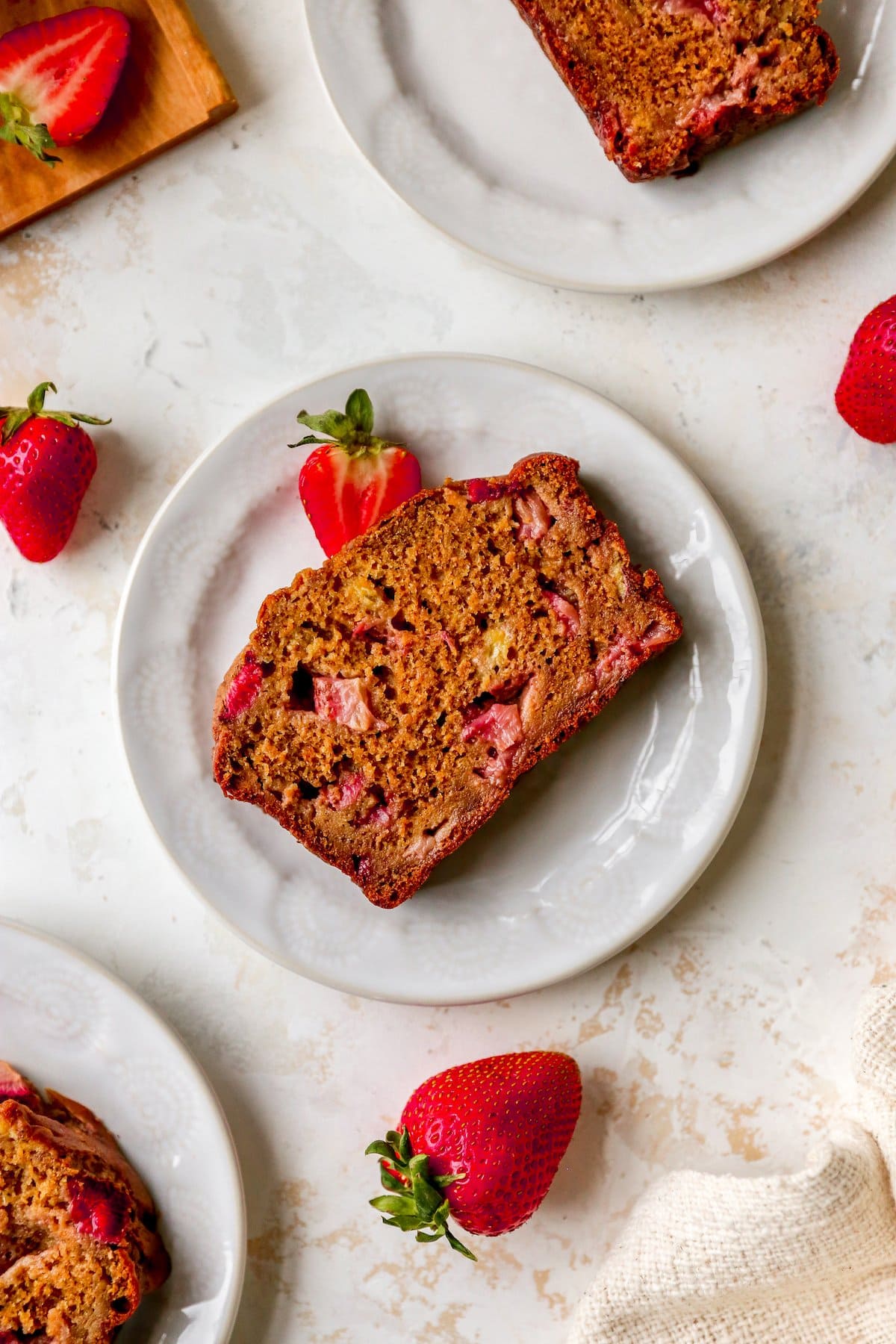 A loaf of strawberry banana bread on a plate.