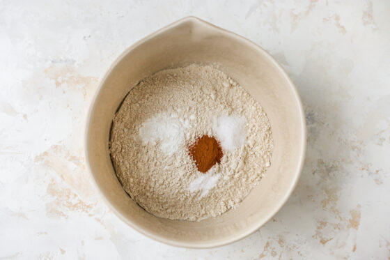 Whole wheat pastry flour, baking powder, baking soda, sea salt and cinnamon in a bowl.
